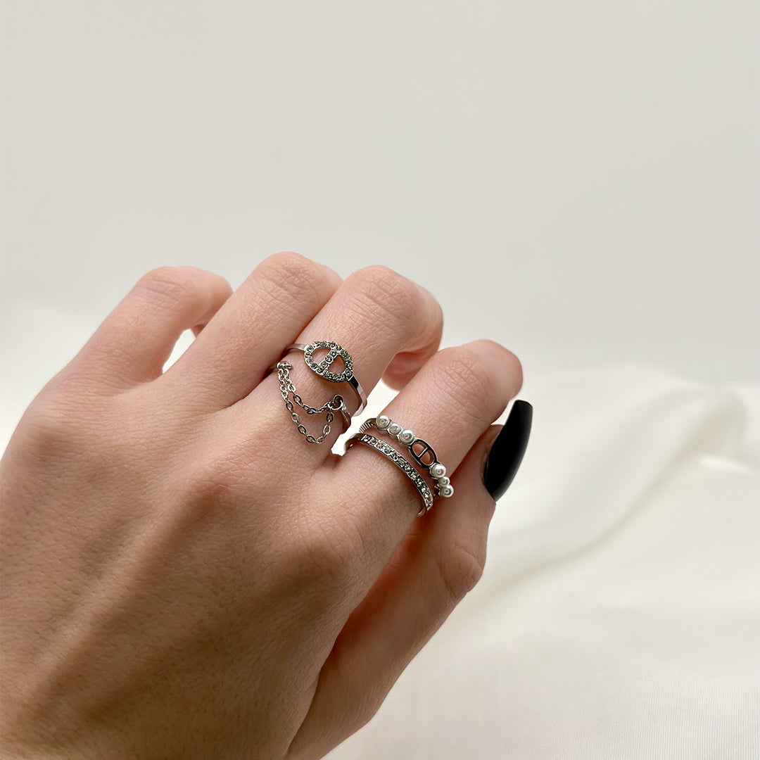 Composition de bagues réglables argentées en acier inoxydable dupe christian dior avec des chaînes qui pendent et des strass et des perles blanches
